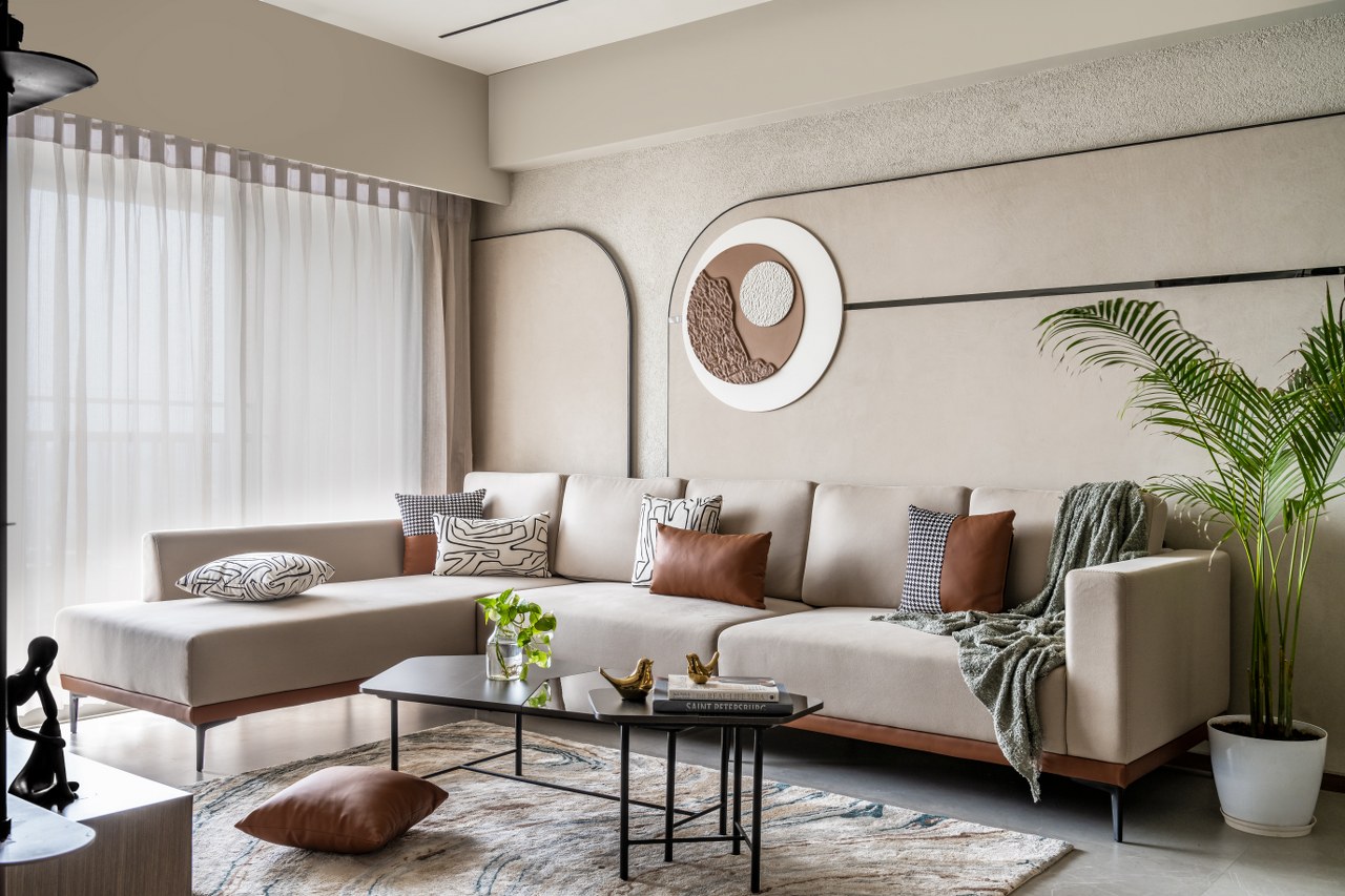  Bright living room with brown leather sofa, beige armchair, yellow throw, and adjacent dining area.